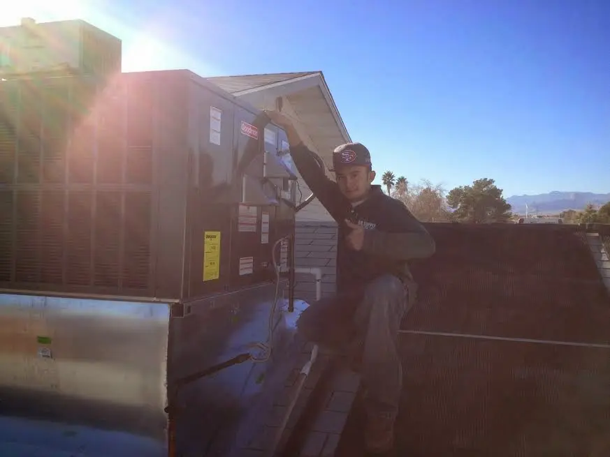 HVAC technician performing HVAC Inspection on a rooftop unit in Oak Grove